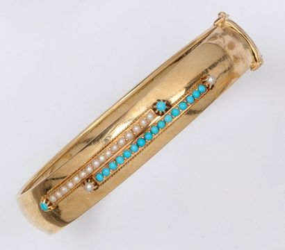 null Bracelet jonc ouvrant en or jaune orné de perles et turquoises. P. 28,4g.