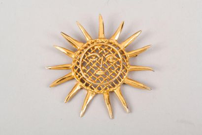 Christian LACROIX Broche soleil en métal doré orné d'un motif grillage, signé sur...