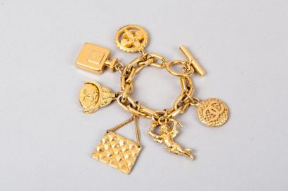 CHANEL circa 1990 Bracelet chaine en métal doré retenant des charms figurant les...