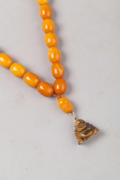 null Chine, XXe siècle Collier comprenant 33 perles en ambre et un pendentif en œil...