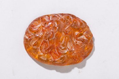 null Chine, XXe siècle Pendentif ovale en ambre, à décor de fleurs de lotus. H. 7...