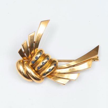 null Broche "Nœud" en or jaune godronné ornée de saphirs. Vers 1940. Dimensions:...