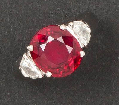 null Bague en or gris ornée d'un rubis taillé en coussin épaulé de deux diamants...