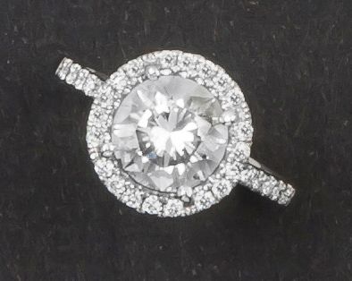 null Bague en or gris ornée d'un diamant taillé en brillant dans un entourage de...