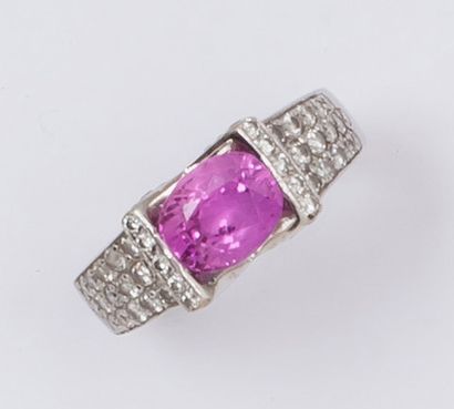 null Bague en or gris ornée d'un saphir rose ovale épaulé de pavages de diamants...