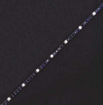 null Bracelet ligne en or gris noirci entièrement serti de diamants alternés de saphirs.
Longueur:...