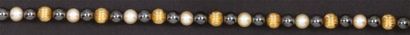 null Collier composé d'un rang de boules d'or jaune godronné alternées de perles...