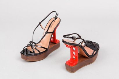 ALAÏA Paire de sandales à brides en cuir vernis noir, talons industriel 125mm en...