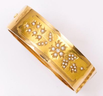 null Bracelet rigide ouvrant en or jaune orné d'un motif floral serti de demi-perles...