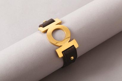 HERMÈS Paris made in France *Bracelet en cuir noir, retenant un motif en métal doré.
Longueur:...