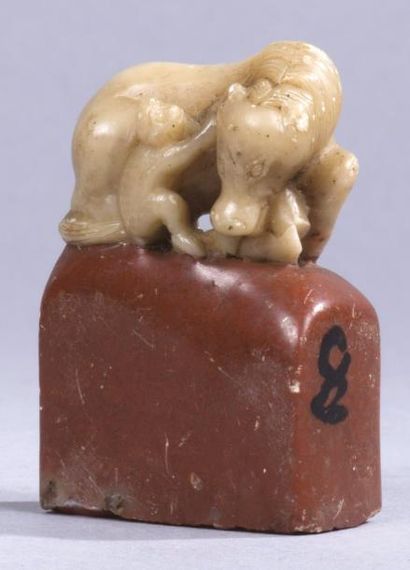 CHINE, XIXe siècle 
Petit sceau en stéatite rouge et beige, la prise sculpté d'un...