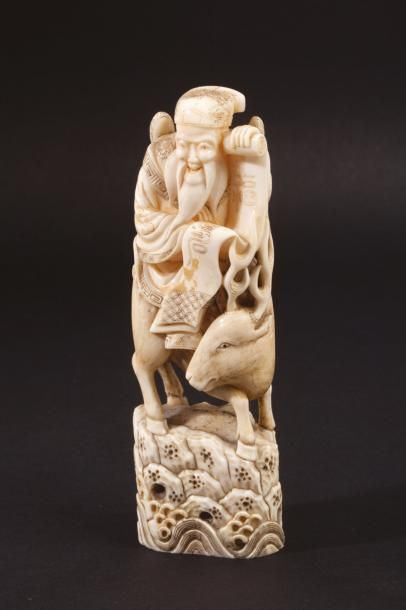 JAPON, vers 1900 
Okimono en ivoire de morse représentant Jurojin sur son daim, déroulant...