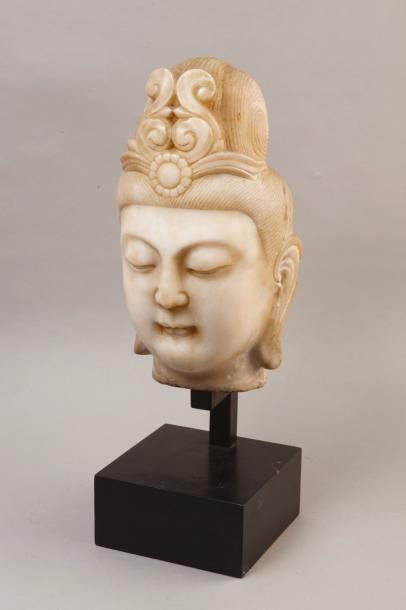 Chine, vers 1930 
Tête de Guanyin en marbre blanc, le visage aux yeux mi-clos, le...