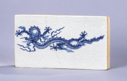 CHINE, XXe siècle 
Brique en porcelaine céladon à décor moulé sous couverte de flots...