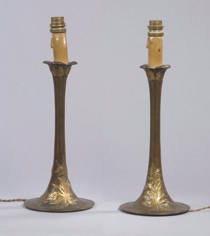 O.MEDNAT (XIX-XXème) 
Paire de bougeoirs en bronze patiné brun et bronze doré à décor...