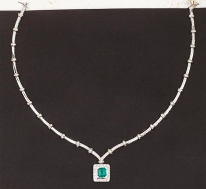 null Collier articulé en or gris serti de diamants orné en son centre d'une émeraude...