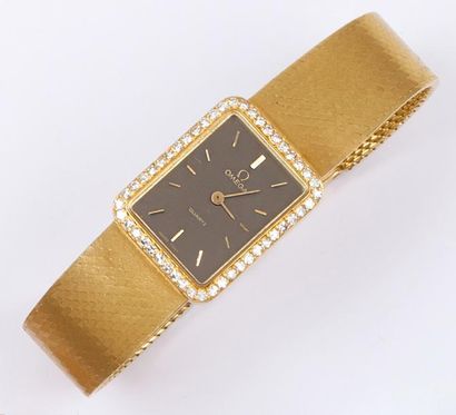 OMEGA Bracelet montre en or jaune. Cadran taupe, index appliqués. Lunette sertie...