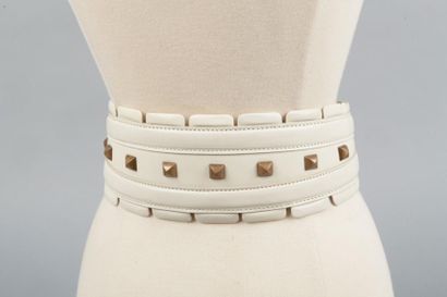 ALAÏA Large ceinture en cuir surpiqué ivoire ornée de clous en métal doré vieilli....