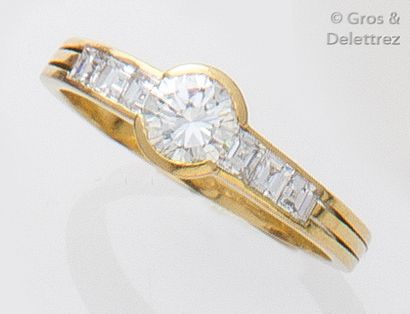 null Bague en or jaune ornée d'un diamant taillé en brillant épaulé de diamants princesses.
Tour...