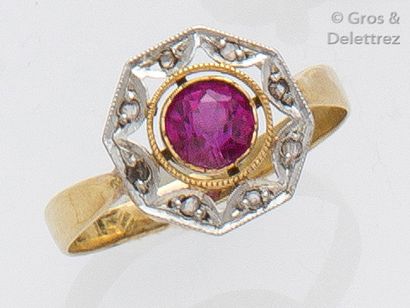 null Bague en or jaune ornée d'une pierre rouge dans un entourage de diamants taillés...