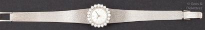 EVIANA Bracelet-montre de dame en or gris, la lunette sertie de diamants taillés...