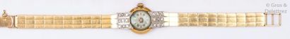 MIDEX Bracelet-montre de dame en or jaune, les attaches serties de diamants taillés...