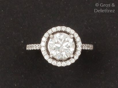 null Bague solitaire en or gris ornée d’un diamant taillé en brillant dans un entourage...