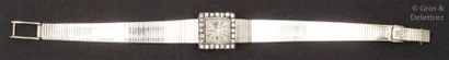 null OMEGA - Bracelet-montre de dame en or gris, la lunette sertie de diamants taillés...