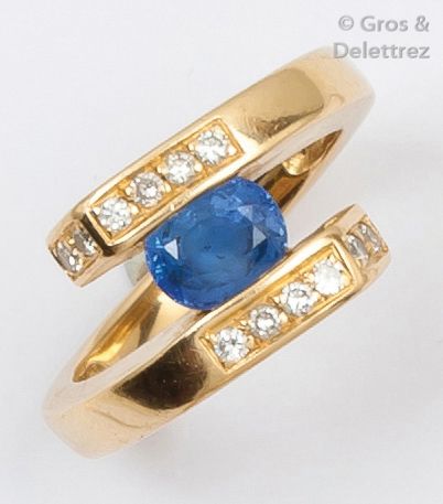 null Bague «?Croisée?» en or jaune ornée d’un saphir ovale bordé de deux lignes de...