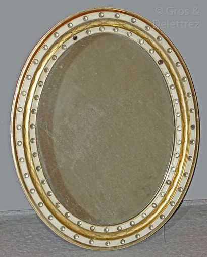 null Miroir ovale en bois laqué ivoire et or, orné de cristaux taillés en pointe...