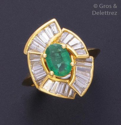 null Bague en or jaune ornée d’une émeraude ovale entourée de lignes de diamants...