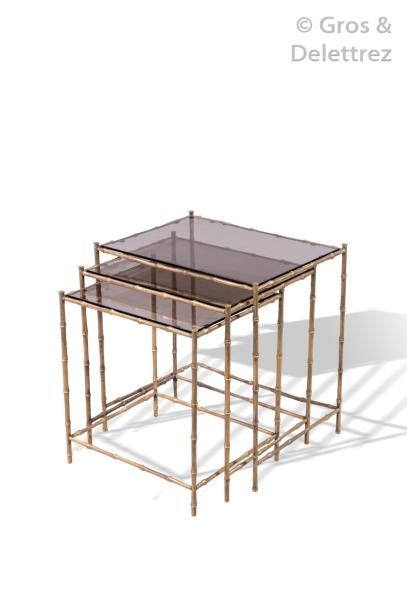 null MAISON BAGUES Suite de trois tables gigognes en bronze doré à plateaux rectangulaires...