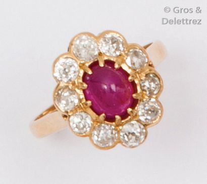 null Bague en or jaune ornée d’un cabochon de rubis dans un entourage de diamants...