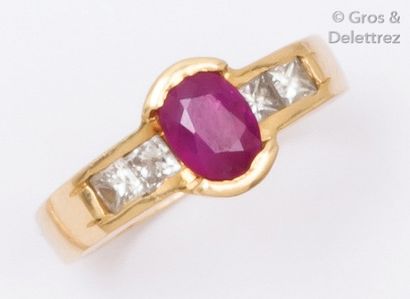 null Bague en or jaune ornée d’un rubis ovale épaulé de quatre diamants princesse....