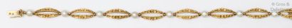 null Bracelet articulé en or jaune ciselé à décor de fleurs et de perles fines boutons....