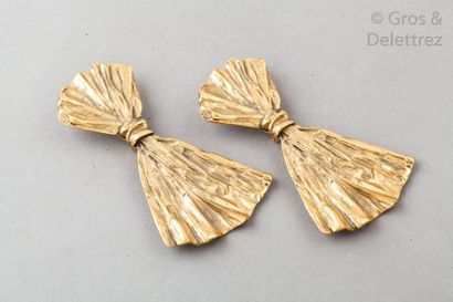 Yves Saint LAURENT Paire de pendants d’oreille en métal doré figurant un drapé. Signée....