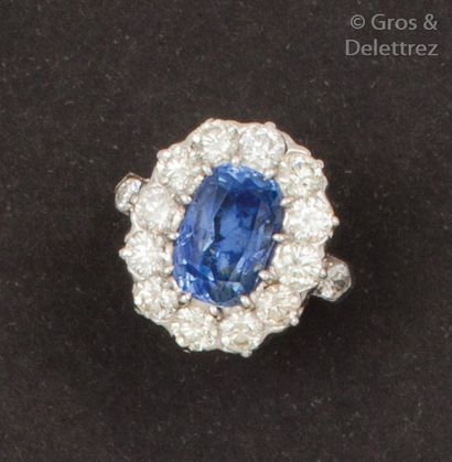 null Bague en or gris ornée d’un saphir ovale dans un entourage et épaulé de diamants...