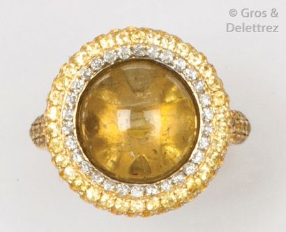 null Bague en or jaune ornée d’un quartz rutile cabochon dans un entourage de diamants...