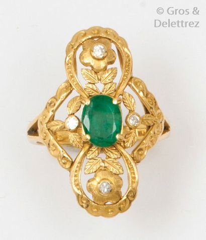 null Bague en or jaune ciselée à décor de fleurs, ornée d’une émeraude ovale bordée...