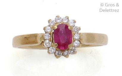 null Bague en or jaune ornée d’un rubis ovale dans un entourage de diamants taillés...