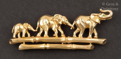 CARTIER Broche en or jaune à décor d’une famille d’éléphants marchant sur une branche...