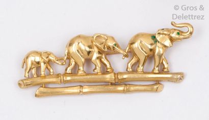 CARTIER Broche en or jaune à décor d’une famille d’éléphants marchant sur une branche...