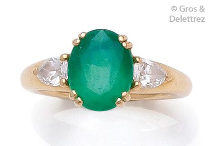 null Bague en or jaune, ornée d'une émeraude ovale épaulée de diamants taillés en...