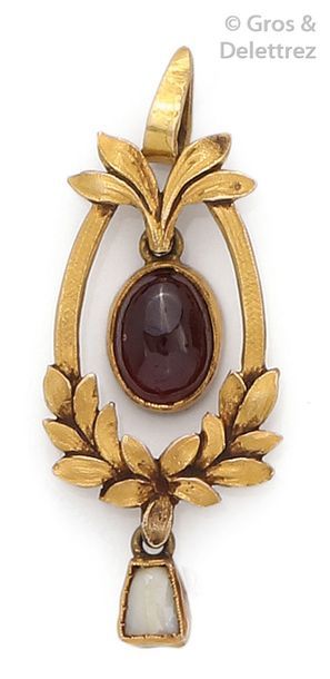 null Pendentif en or jaune à décor de feuilles, orné d'un grenat cabochon soutenu...