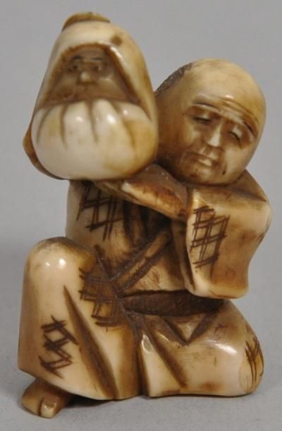 null Netsuke en ivoire sculpté représentant un personnage assis portant un bébé....