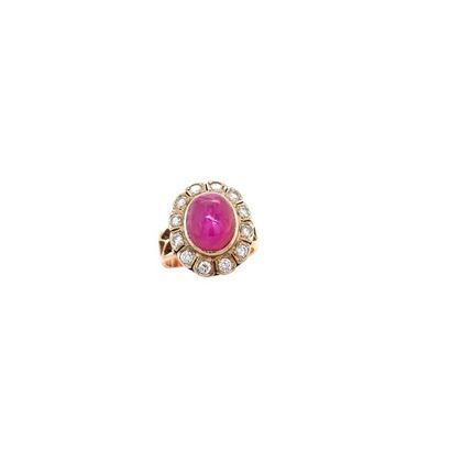 null Daisy ring in gold (750) decorated with a ruby cabochon in an entourage of 12...