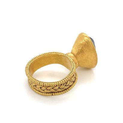 Importante BAGUE en or (750) ornée d'une frise rubanée soulignée de deux rangs perlés,...