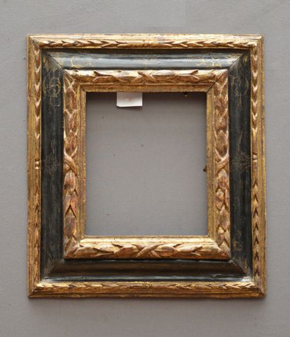 null Reverse profile frame in carved, gilded and blackened wood with laurel twist...