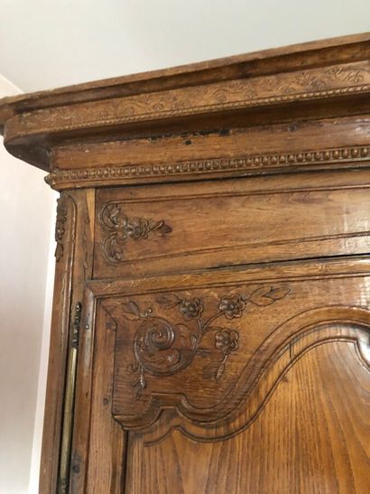 null ARMOIRE en chêne blond ,ouvrant par deux portes, mouluré et sculpté de rinceaux...