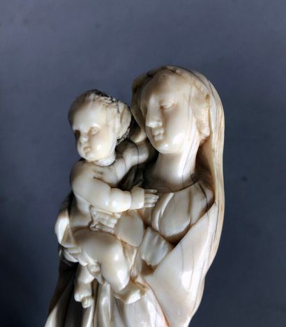  VIERGE à l'enfant en ivoire sculpté (tête de l'enfant recollé) sur un socle en bois...